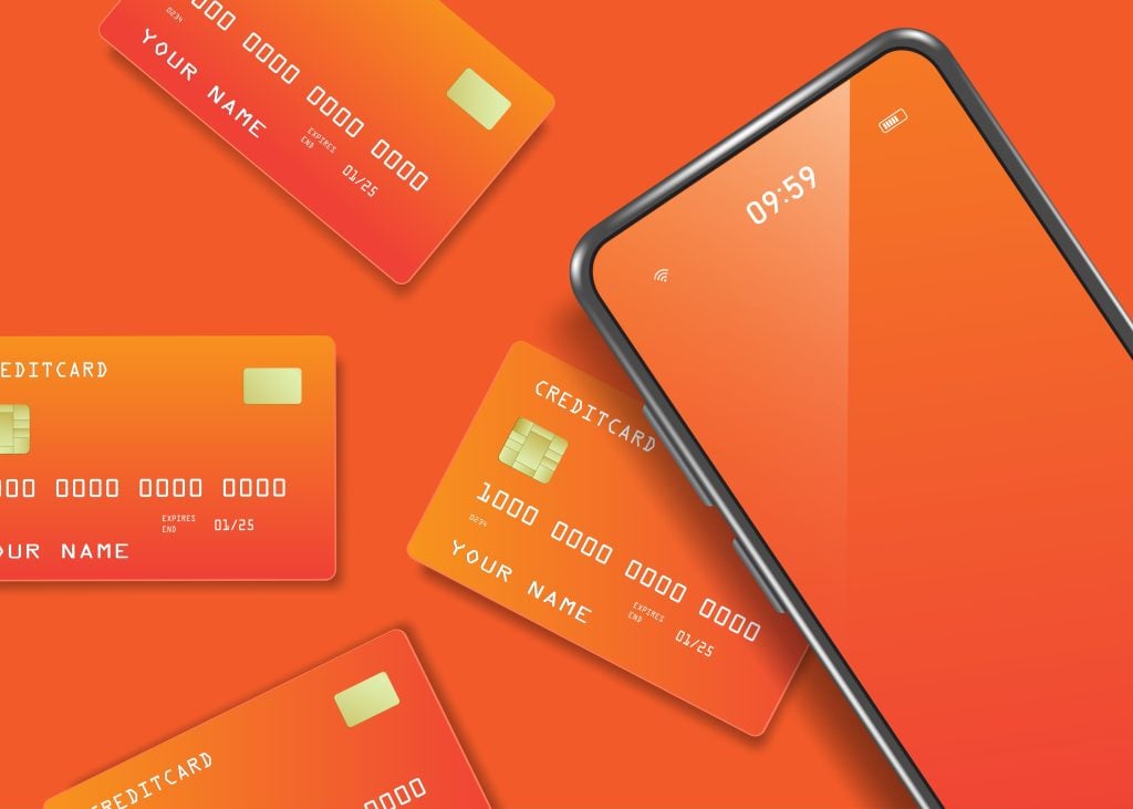 Several orange credit cards positioned alongside a cellphone.
